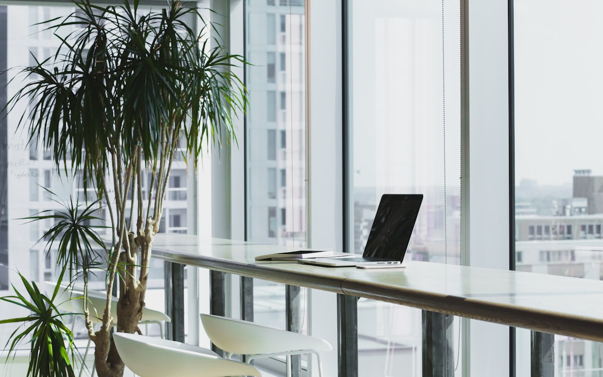 Black and white photograph of a quiet modern office interior with tall windows
